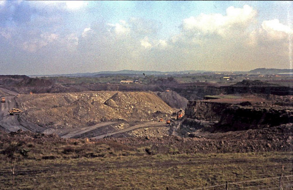 A large opencast mine with bright orange machinery