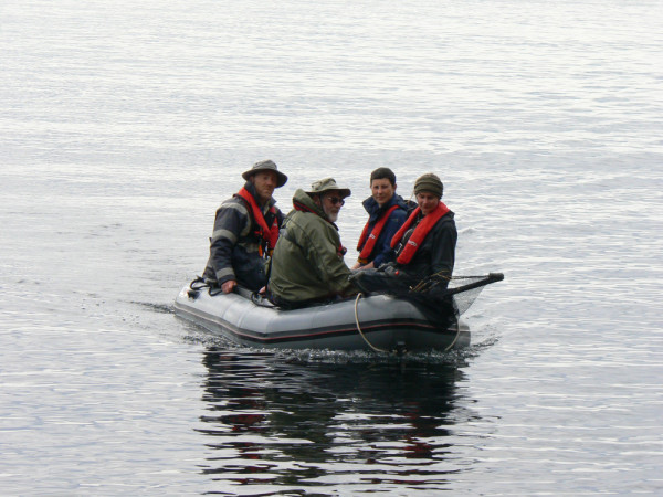 Photograph of four team people in an rigid inflatable boat. 